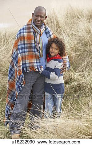 Father And Son Wrapped In Blanket Amongst Dunes On Winter Beach View Large Photo Image Stock Image - Father And Son Wrapped In Blanket Amongst Dunes On Winter Beach. Fotosearch