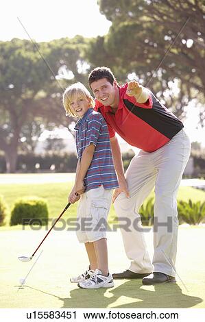 Stock Image - Father Teaching Son To Play Golf On Putting On Green. Fotosearch