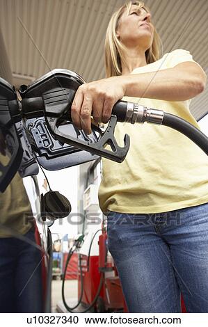 Stock Image - Female Motorist Filling Car With Diesel At Petrol Station. Fotosearch