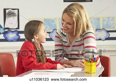 Female Primary School Pupil And Teacher Working At Desk In Classroom View Large Photo Image Stock Image - Female Primary School Pupil And Teacher Working At Desk In Classroom. Fotosearch