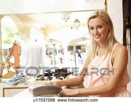 Female Sales Assistant At Checkout Of Clothing Store View Large Photo Image Stock Photo - Female Sales Assistant At Checkout Of Clothing Store. Fotosearch
