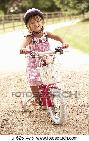 Girl Learning To Ride Bike Wearing Safety Helmet View Large Photo Image Stock Photography - Girl Learning To Ride Bike Wearing Safety Helmet. Fotosearch