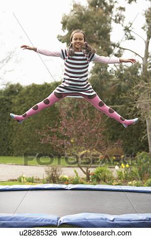 Stock Photograph - Girl Playing On Trampoline. Fotosearch