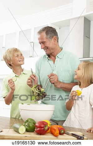 Grandchildren Helping Grandfather To Prepare Salad In Modern Kitchen View Large Photo Image Stock Image - Grandchildren Helping Grandfather To Prepare Salad In Modern Kitchen. Fotosearch