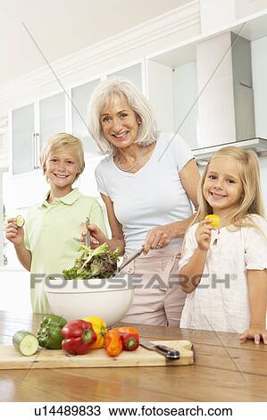 Grandchildren Helping Grandmother To Prepare Salad In Modern Kitchen View Large Photo Image Stock Image - Grandchildren Helping Grandmother To Prepare Salad In Modern Kitchen. Fotosearch