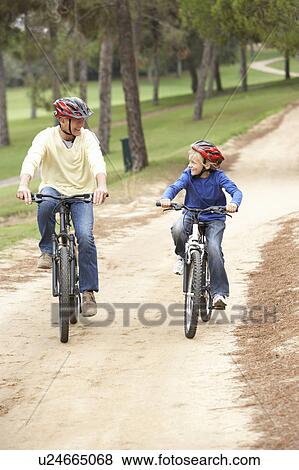Grandfather and grandson riding bicycle in park View Large Photo Image Stock Photo - Grandfather and grandson riding bicycle in park. Fotosearch
