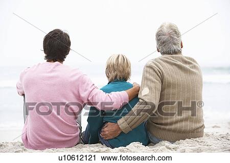 Stock Image - Grandfather, Father And Grandson Sitting On Winter Beach. Fotosearch