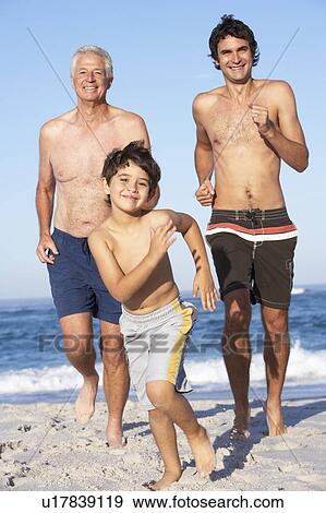 Stock Photo - Grandfather, Father and Grandson Running Along Beach. Fotosearch