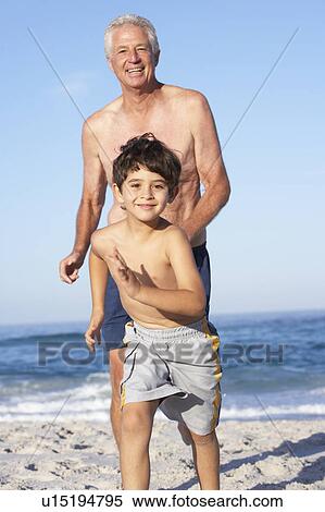 Stock Photography - Grandfather, Father and Grandson Running Along Beach. Fotosearch