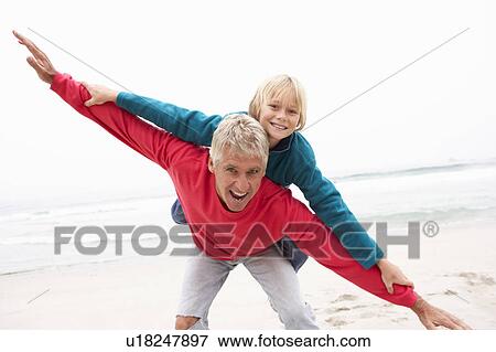 Grandfather Giving Grandson Piggy Back On Winter Beach View Large Photo Image Stock Photo - Grandfather Giving Grandson Piggy Back On Winter Beach. Fotosearch