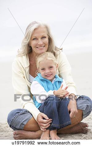Grandmother And Granddaughter On Holiday Sitting On Winter Beach View Large Photo Image Stock Image - Grandmother And Granddaughter On Holiday Sitting On Winter Beach. Fotosearch
