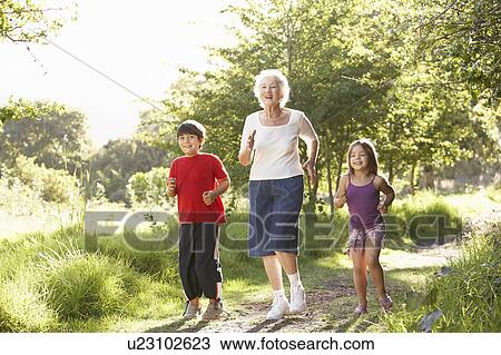 Stock Image - Grandmother Jogging In Park With Grandchildren. Fotosearch