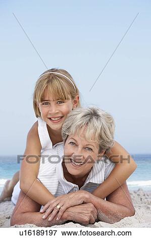 Grandmother Relaxing On Sandy Beach With Granddaughter View Large Photo Image Stock Photo - Grandmother Relaxing On Sandy Beach With Granddaughter. Fotosearch