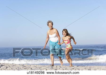 Grandmother Running With Granddaughter Along Sandy Beach View Large Photo Image Stock Photo - Grandmother Running With Granddaughter Along Sandy Beach. Fotosearch
