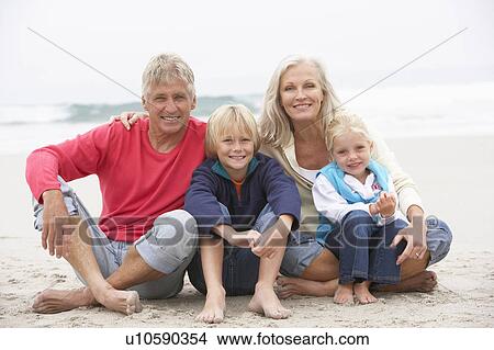 Picture - Grandparents And Grandchildren Sitting On Winter Beach Together. Fotosearch