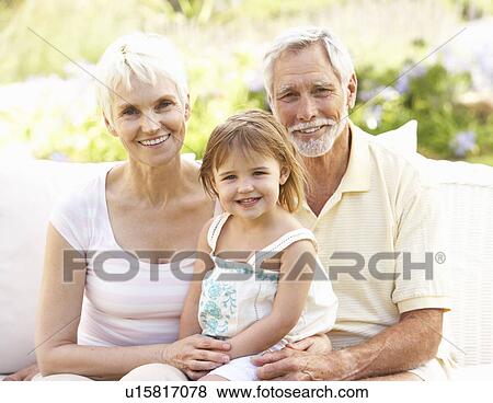 Grandparents And Granddaughter Relaxing In Garden View Large Photo Image Stock Photo - Grandparents And Granddaughter Relaxing In Garden. Fotosearch