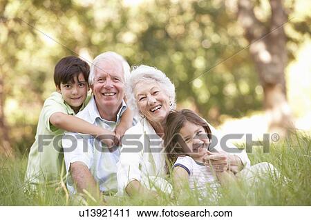 Stock Image - Grandparents In Park With Grandchildren. Fotosearch