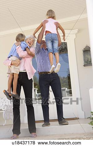 Grandparents Welcoming Grandchildren On Visit To Home View Large Photo Image Stock Photo - Grandparents Welcoming Grandchildren On Visit To Home. Fotosearch