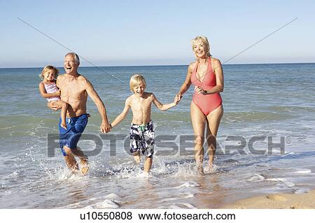 Grandparents With Grandchildren Enjoying Beach Holiday Together View Large Photo Image Stock Photo - Grandparents With Grandchildren Enjoying Beach Holiday Together. Fotosearch