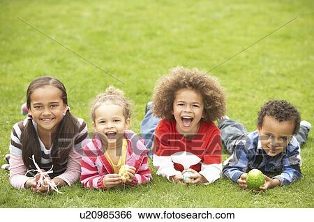 Group Of Children Laying On Grass With Easter Eggs View Large Photo Image Stock Photograph - Group Of Children Laying On Grass With Easter Eggs. Fotosearch