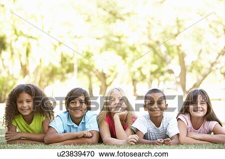 Stock Image - Group Of Children Lying On Stomachs In Park. Fotosearch