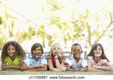 Stock Photo - Group Of Children Lying On Stomachs In Park. Fotosearch