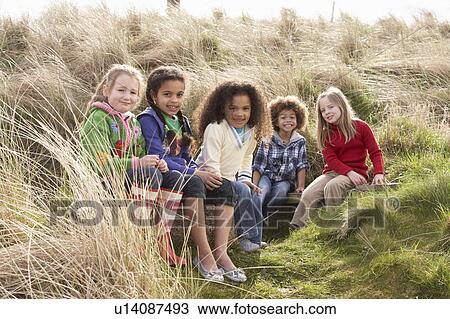 Stock Image - Group Of Children Playing In Field Together. Fotosearch