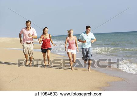 Stock Image - Group Of Friends Enjoying Beach Holiday. Fotosearch