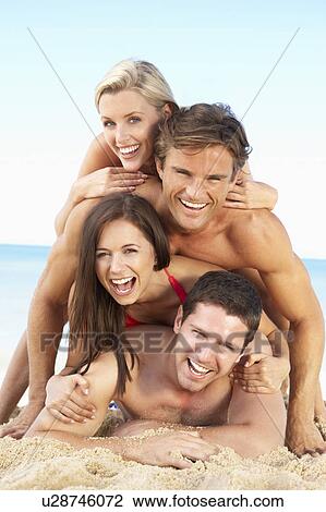 Stock Image - Group Of Friends Enjoying Beach Holiday. Fotosearch