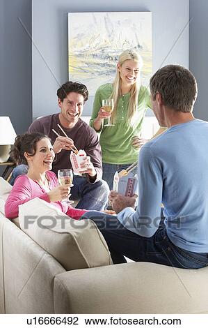 Stock Image - Group Of Friends Enjoying Chinese Takeaway Meal At Home. Fotosearch