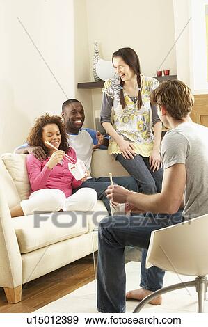 Stock Photo - Group Of Friends Enjoying Chinese Takeaway Meal At Home. Fotosearch