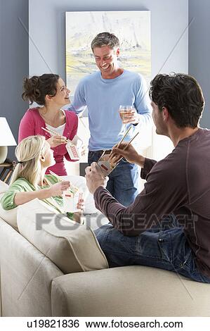 Stock Photograph - Group Of Friends Enjoying Chinese Takeaway Meal At Home. Fotosearch