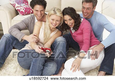 Group Of Friends Looking At Pictures On Digital Camera At Home View Large Photo Image Picture - Group Of Friends Looking At Pictures On Digital Camera At Home . Fotosearch