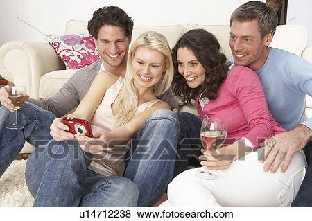 Group Of Friends Looking At Pictures On Digital Camera At Home View Large Photo Image Stock Photo - Group Of Friends Looking At Pictures On Digital Camera At Home. Fotosearch