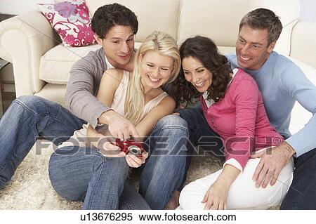 Group Of Friends Looking At Pictures On Digital Camera At Home View Large Photo Image Stock Photography - Group Of Friends Looking At Pictures On Digital Camera At Home . Fotosearch