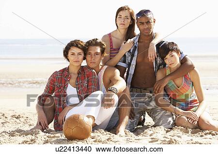 Group Of Friends Relaxing On Beach With Football Together View Large Photo Image Stock Image - Group Of Friends Relaxing On Beach With Football Together. Fotosearch