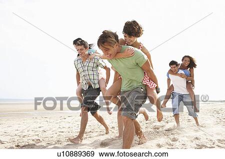 Stock Photo - Group Of Friends Running Along Beach Together. Fotosearch