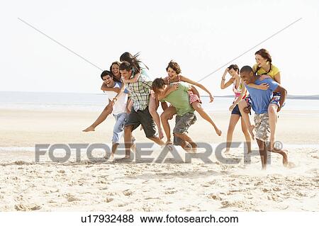 Group Of Friends Running Along Beach Together View Large Photo Image Stock Photo - Group Of Friends Running Along Beach Together. Fotosearch