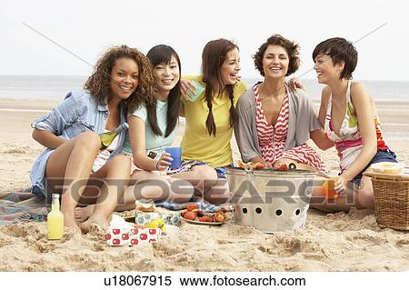 Stock Photography - Group Of Girls Enjoying Barbeque On Beach Together. Fotosearch