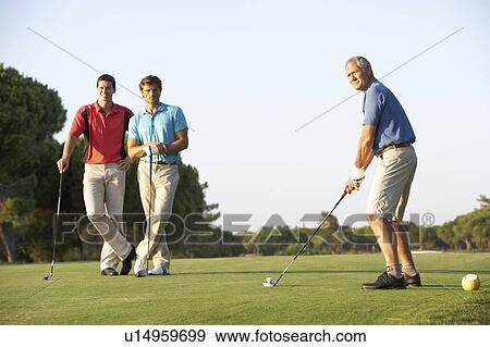 Group Of Male Golfers Teeing Off On Golf Course View Large Photo Image Stock Photo - Group Of Male Golfers Teeing Off On Golf Course. Fotosearch