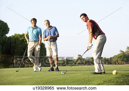 Stock Photography - Group Of Male Golfers Teeing Off On Golf Course. Fotosearch