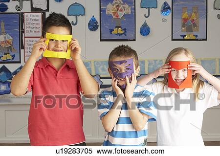 Stock Photography - Group Of Primary School Children Cutting Out Paper Shapes In Craft Lesson. Fotosearch