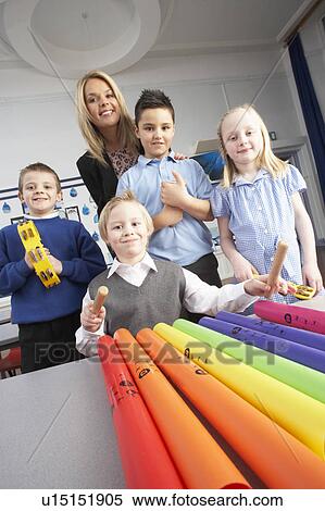 Group Of Primary Schoolchildren And Teacher Having Music Lesson In Classroom View Large Photo Image Stock Photography - Group Of Primary Schoolchildren And Teacher Having Music Lesson In Classroom. Fotosearch