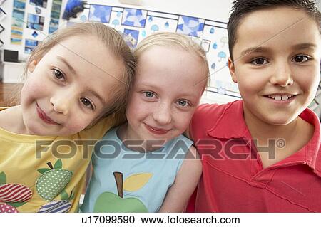 Stock Image - Group Of Primary Schoolchildren In Classroom. Fotosearch