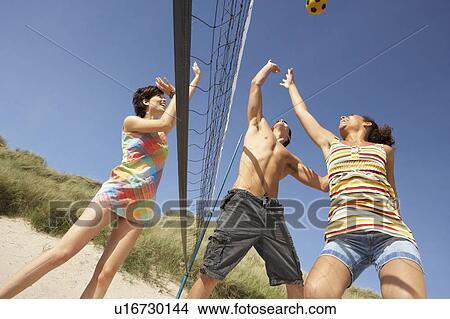 Picture - Group Of Teenage Friends Playing Volleyball On Beach. Fotosearch