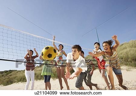 Group Of Teenage Friends Playing Volleyball On Beach View Large Photo Image Stock Photo - Group Of Teenage Friends Playing Volleyball On Beach. Fotosearch