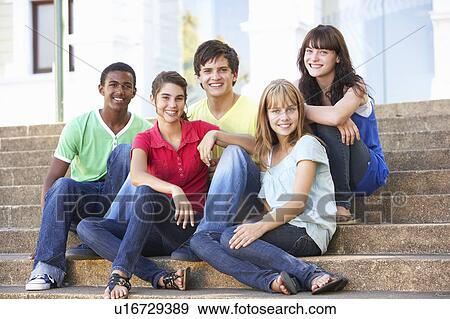 Stock Photo - Group Of Teenage Friends Sitting On College Steps Outside. Fotosearch