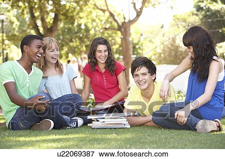 Group Of Teenage Students Chatting Together In Park View Large Photo Image Stock Photo - Group Of Teenage Students Chatting Together In Park. Fotosearch