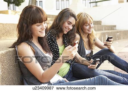 Group Of Teenage Students Sitting Outside On College Steps Using Mobile Phone View Large Photo Image Stock Photo - Group Of Teenage Students Sitting Outside On College Steps Using Mobile Phone. Fotosearch