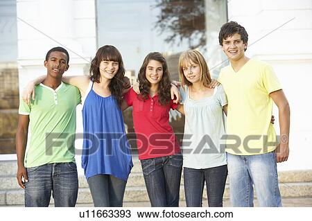 Stock Image - Group Of Teenage Students Standing Outside College Building. Fotosearch